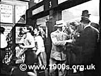 1940s ticket collector checking and collecting passengers' train tickets as they leave a platform at a large city rail terminus