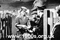 1940s ticket collector checking and collecting passengers' train tickets at the end of a journey to a small rural station