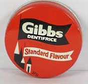 Tin of Gibb's Dentifrice toothpaste - a solid pink 'cake' in either a red, green or blue tin