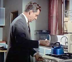 Lighting the gas under a blue anodised whistling kettle, 1950s or 1960s