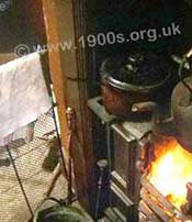 Damp clothes hanging over a fireguard to dry from the heat of the kitchen range