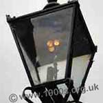 Three lighted mantles in an old gas street lamp